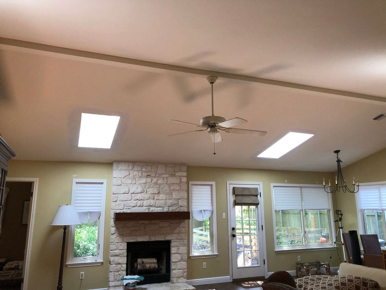 A living room with a fireplace and ceiling fan.