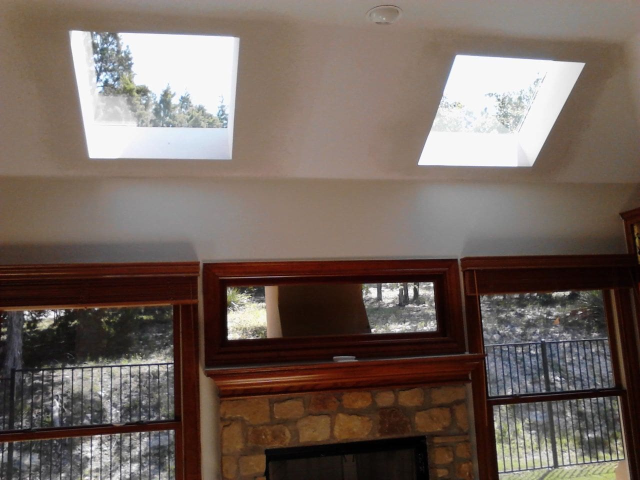 A fireplace with two skylights above it.