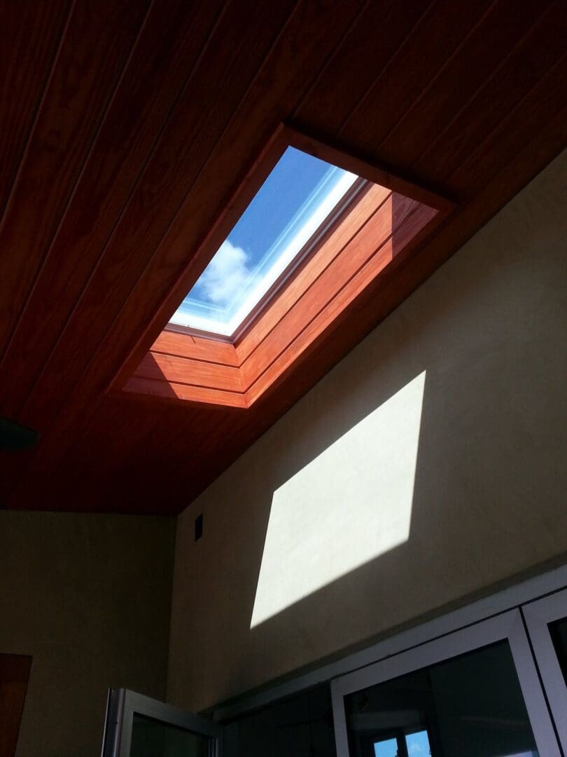 A skylight in the middle of a room with a window.