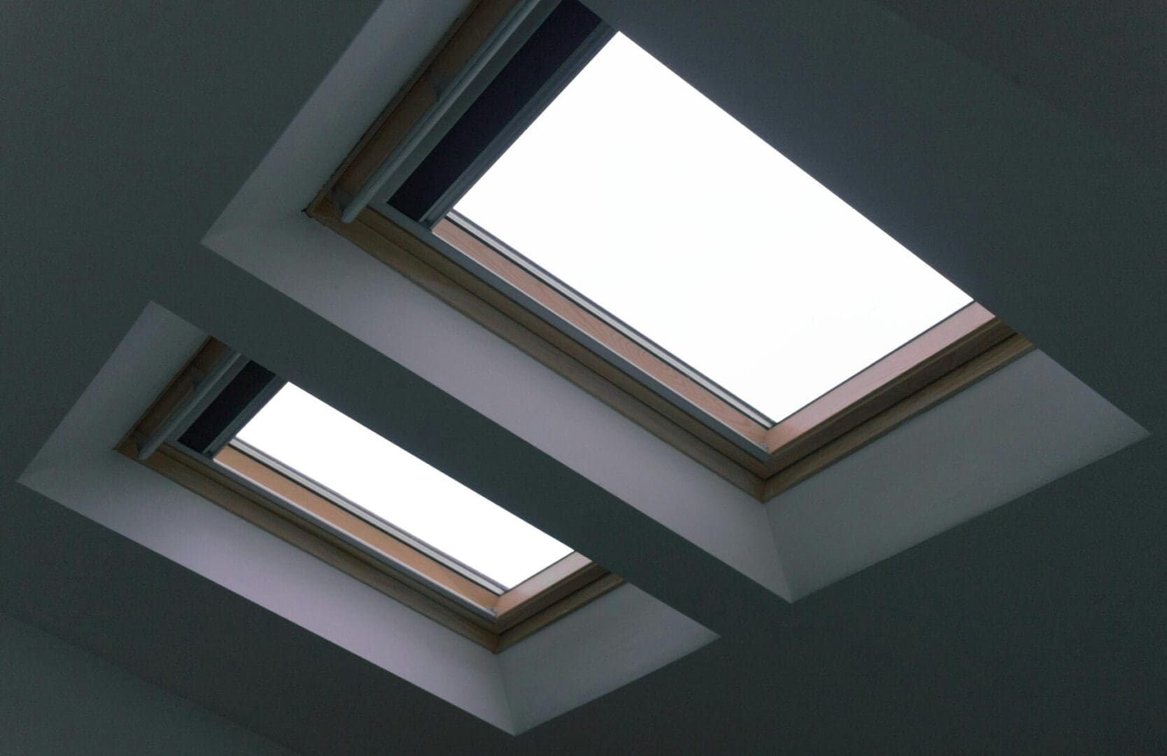 Two skylights in a room with white walls.